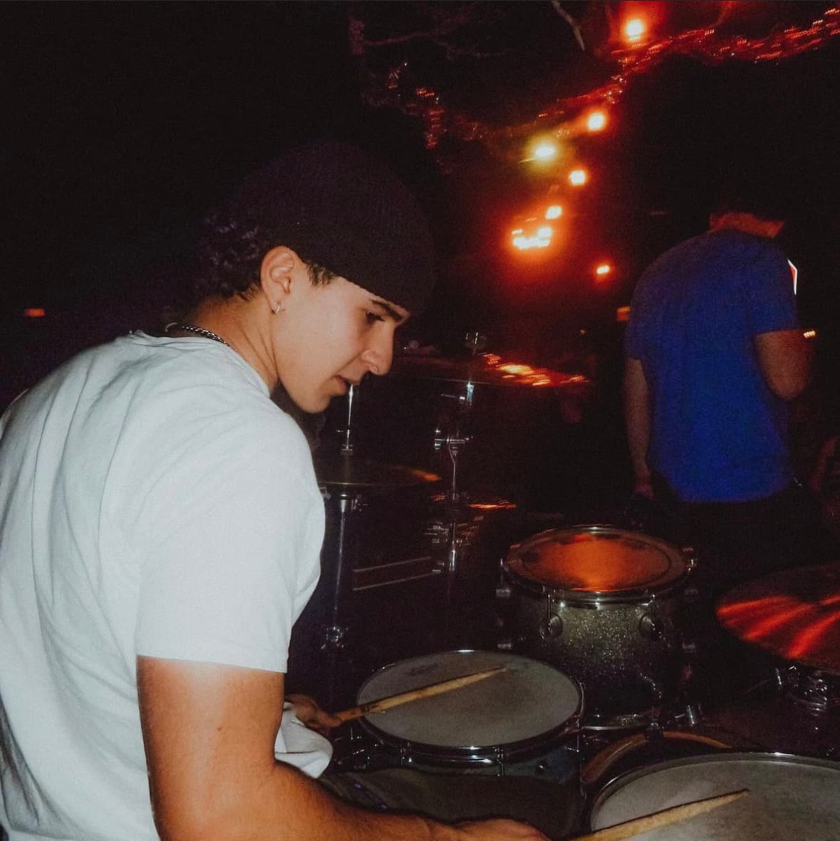 Ryan playing drums at an evening outdoor performance